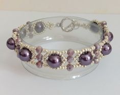 This pretty bracelet is made with bright silver coloured seed beads, purple pearls and small purple rondelle crystals , which are quite sparkly. It fastens with  a silver tone toggle clasp . Sized to fit a 6.75"/ 17.2cm  wrist and is approx. 0.4"/1.5 cm wide.  My own design. Elegant Purple Beaded Bracelets With Silver Beads, Purple Beaded Bracelets With Silver Beads For Jewelry Making, Purple Beaded Pearl Bracelets, Elegant Purple Crystal Bracelet With Spacer Beads, Purple Beaded Pearl Bracelet, Pearl Beaded Bracelets With Silver Beads, Purple Beaded Pearl Bracelet With Round Beads, Silver Beaded Pearl Bracelets, Elegant Purple Spacer Beads