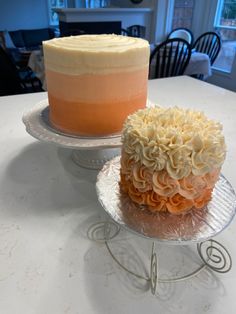 two cakes sitting on top of each other on metal trays, one with frosting and the other with icing