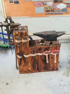 an old wooden box with tools attached to it sitting on the floor in front of a bulletin board