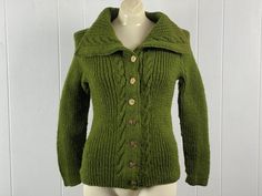 a mannequin wearing a green sweater and jacket