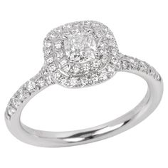 a white gold ring with an oval cut diamond surrounded by small round brilliant pave diamonds