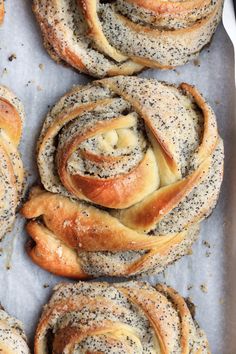 several different types of breads on a baking sheet with poppy seed sprinkles