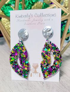 Purple green and gold fun Mardi Gras earrings. Made with glitter and resin, lightweight. Comes with gold tone studs, lead and nickel free. Will come gift wrapped, ships free. Hang down 2 in. from ear. Multicolor Glitter Dangle Earrings, Multicolor Glitter Drop Earrings, Green Pierced Jewelry For Party, Nickel-free Green Earrings For Party, Green Nickel-free Party Earrings, Green Pierced Earrings For Party, Multicolor Resin Jewelry For Party, Trendy Multicolor Glitter Jewelry, Purple Glitter Party Jewelry