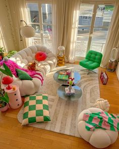 a living room filled with lots of furniture and decor on top of a hard wood floor