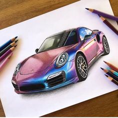 a drawing of a pink and blue car on paper with colored pencils next to it