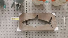 some toys are hanging on the wall and one is shaped like a shark with sharp teeth