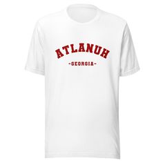 Want to rep Atlanta in style, whether you're cheering on the Braves, Falcons, or Atlanta FC? Our Atlanuh Varsity shirt has you covered. Made from 100% combed and ring-spun cotton (Heather colors contain polyester), this shirt is comfortable, durable, and perfect for any occasion. The classic fit and side-seamed construction provide a flattering silhouette, and the shoulder-to-shoulder tapping adds extra durability. But the real reason you'll want to rock this shirt is the bold 'ATLANUH' design i Cotton Slogan T-shirt For Fan Gear, White Varsity T-shirt With Screen Print, Cotton Team Spirit T-shirt With Slogan, White Slogan T-shirt For College, Relaxed Fit Slogan T-shirt For College, Collegiate Cotton T-shirt With Slogan, Cotton Varsity Slogan Tops, Cotton Varsity Tops With Slogan, Collegiate White T-shirt With Text Print