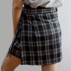 Plaid shorts with a belted skirt overlay and concealed side zipper. S: 26" waist, 15.5" length M: 27.5" waist, 15.5" length L: 29" waist, 15.5" lengthXL: 30.5" waist, 16" length2XL: 32" waist, 16" length3XL: 33.5" waist, 16" length4XL: 35" waist, 16.5" length5XL: 36.5" waist, 16.5" length Trendy Short Skirt With Belt Loops, Casual Belted Mini Skort, Summer Asymmetrical Skirt With Belt Loops, Casual Short Belted Skirt, Trendy Skort With Belt Loops, Casual Belted Skirt Bottoms, Spring Bottoms With Belt Loops And Asymmetrical Hem, Relaxed Asymmetrical Skirt With Belt Loops, Chic Bottoms With Belt Loops And Asymmetrical Hem