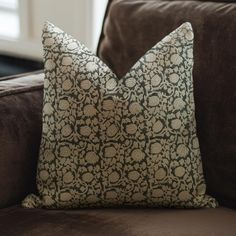 a brown couch with a decorative pillow on it