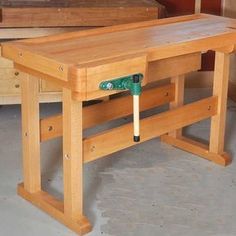 a wooden work bench with a hammer in it's center and two drawers on the other side