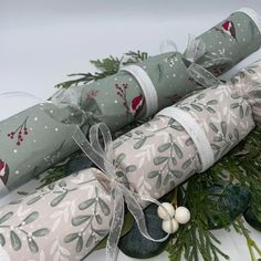 three rolled up wrappings on top of evergreen branches