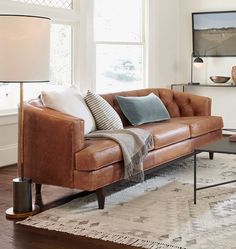 a living room with a couch, table and lamp in it's centerpiece