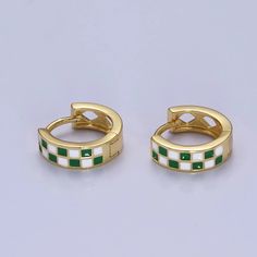 Our 24K Gold Filled Enamel Checker Hoops are the most adorable small hoop earrings. We love the checker pattern. Available in Gold Filled with green and blue accents. - Material: Brass, 24K Gold Filled - Size: 12 x 13 mm Trendy Green Enamel Earrings, Green Round Huggie Earrings As Gift, Green Round Huggie Earrings For Gifts, Green Hypoallergenic Small Hoop Huggie Earrings, Trendy Green Huggie Hoop Earrings, Hypoallergenic Green Small Hoop Huggie Earrings, Trendy Green Huggie Jewelry, Hypoallergenic Small Green Huggie Earrings, Green Enamel Hoop Jewelry