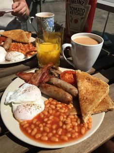 a plate with eggs, toast, beans and bacon on it