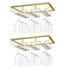 four wine glasses hanging from a gold shelf