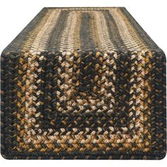 a brown and black rug on top of a wooden table with an odd design in the middle