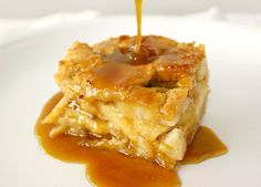 caramel sauce being drizzled over a piece of apple pie on a white plate