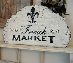 a sign that says french market on the side of a wall next to a potted plant