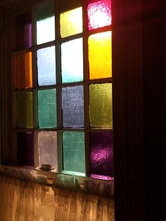 a close up of a window with many different colored glass panes on the windowsill