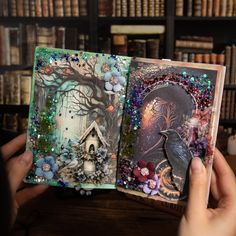 a person holding an open book with pictures and beads on it in front of a bookshelf