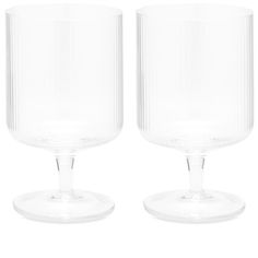 two clear glass goblets sitting side by side on a white background, one is empty