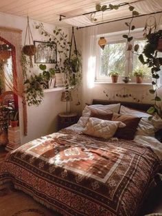 a bed in a room with plants on the wall and a hanging planter next to it