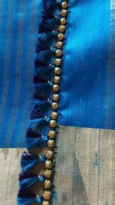 blue and gold fabric with tassels on it