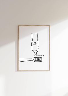 a black and white drawing of a toothbrush in front of a framed poster on the wall