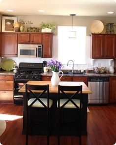 a kitchen filled with lots of wooden cabinets and counter top next to a stove top oven