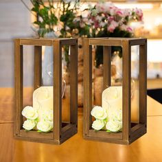 two wooden boxes with flowers in them on a table