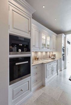 a large kitchen with white cabinets and marble counter tops is pictured in this image from the front view