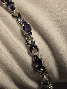 This Blue Iolite bracelet is very lively and bright. The stones are deep colors and well matched. The sterling silver is plated with rhodium to protect the bracelet from tarnish and give the appearance of white gold. 7.5 inches All jewelry is shipped in a nice gift box. Check out our over a THOUSAND great reviews Engraving is $4 per letter and is not always perfect depending on the piece. It can take a few days if the jeweler is busy. This is payable to Paypal Judithsltd@gmail.com Elegant Silver Tennis Bracelet With Amethyst, Elegant Silver Amethyst Tennis Bracelet, Elegant Silver Tennis Bracelet, Elegant Purple Sterling Silver Jubilee Bracelet, Silver Tanzanite Gemstones With Accents, Silver Amethyst Tennis Bracelet With Gemstones, Silver Tanzanite Bracelet In Fine Jewelry Style, Silver Tanzanite Bracelet Fine Jewelry, Tanzanite Gemstone Bracelet For Anniversary