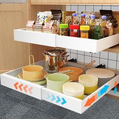 an open drawer in a kitchen filled with dishes and cooking utensils