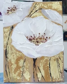 an acrylic painting of two white flowers on a gold and brown background,