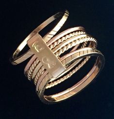 This is my elegant twist to the ring stacking fashion, with an opportunity to make it incredibly personal. Seven solid gold rings together! 7 Gorgeous solid 14k gold handmade rings wrapped together with a double clad gold filled band. You determine what (if anything) you want stamped on Stackable Yellow Gold Jewelry With Modern Twist, Stackable 14k Gold Bypass Ring With Open Band, 14k Gold Stackable Bypass Ring With Open Band, Luxury Double Band 14k Gold Jewelry, Rose Gold Stackable Rings With Modern Twist, Rose Gold Stackable Open Rings With A Modern Twist, Stackable Modern Twist Yellow Gold Jewelry, Luxury 14k Gold Stackable Engraved Ring, Gold Stackable Rings In 14k Rose Gold