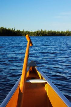 a yellow boat with a long oar in the water