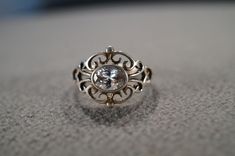 I am offering you this vintage sterling silver, wedding band stacker design ring. It features an oval shaped prong set genuine white topaz stones This stone is set in a scrolled single stone setting. There is fabulous raised relief design work here. It is measuring app. 3/4 inch, by app. 1/2 inch. It is currently a size 8 , though I am sure it could be sized up or down. It weighs app. 4.5 grams. Look at the detail of the design work of this vintage ring Simply breathtaking. This ring came out of Classic White Topaz Ring For Wedding, Classic White Topaz Wedding Ring, Classic Silver Oval Diamond Ring, Vintage White Diamond Ring In Sterling Silver, Vintage White Sterling Silver Diamond Ring, Victorian Style White Diamond Ring With Oval Shape, Victorian Style Oval White Diamond Ring, Oval Topaz Ring With Rose Cut Diamonds For Wedding, Victorian White Oval Diamond Ring