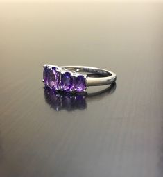 DeKara Designs Silver Metal- 14K White Gold, .583. Stones- 5 Natural Oval Amethyst, Center is 6.9 x 5 MM, Next To Center 6 x 4.3 MM, and last two are 4.9 x 3 MM. Size- Size- PLEASE ALLOW 5-7 WORKING DAYS FOR US TO SHIP OUT YOUR RING IN YOUR SPECIFIC SIZE AFTER TRANSACTION HAS BEEN COMPLETED PLEASE SPECIFY SIZE UPON CHECKOUT! An alternative to a diamond ring, here is timeless beautiful handmade 5 stone amethyst engagement ring. All the amethyst are fiery and set between 4 prongs. Very affordable Purple Multi-stone Amethyst Ring In Fine Jewelry Style, Purple Multi-stone Amethyst Ring Fine Jewelry, Fine Jewelry Purple Amethyst Multi-stone Ring, Purple Multi-stone Amethyst Ring, Tanzanite Three Stone Wedding Jewelry, Heirloom Multi-stone Amethyst Ring, Purple Sterling Silver Gemstones For Wedding, Fine Jewelry Amethyst Gemstones For Wedding, Purple Tanzanite Multi-stone Rings