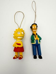 two cartoon characters are hanging from key chains