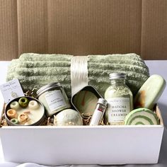 the spa gift box is filled with personal care products and handmade soaps, candles, and body scrubs