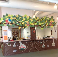 an office decorated with paper cut outs and trees on the front desk for children to play in