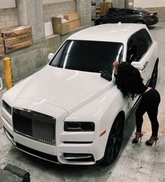 a woman leaning on the hood of a white car