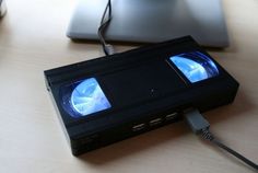 an old video game console sitting on top of a desk next to a laptop computer