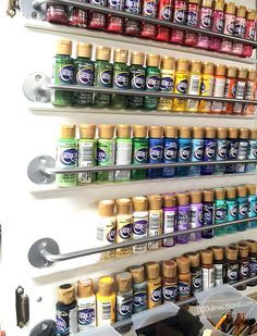 the wall is filled with many different types of paint and brushes, including one for each color