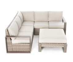 a wicker couch and ottoman with cushions