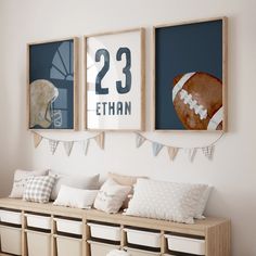 three framed sports pictures hang on the wall above a bench with pillows and storage bins