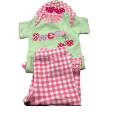 Dress Your Little One In This Adorable Gerber Baby Outfit Set, Featuring A Charming Cherry Design. This 3-Piece Set Includes A Onesie, Leggings, And A Matching Hat, Perfect For Babies Aged 0-3 Months. Made From Soft And Comfortable Fabric, This Outfit Is Ideal For Everyday Wear Or Special Occasions. The Onesie Is Green With "Sweet" And Cherry Embroidery, While The Pink Gingham Leggings And Hat Complete The Cute Ensemble. The Leggings Feature A Ruffled Hem For Added Style, And The Hat Has A Cherr Pink Cotton Sleepover Set, Pink Bedtime Sets For Spring, Pink Spring Bedtime Sets, Cute Pink Sets With Short Sleeves, Sweet Cotton Onesie For Playtime, Playful Fitted Sets For Sleepovers, Pink Spring Sleepover Sets, Cute Fitted Playtime Sets, Cute Fitted Sets For Playtime