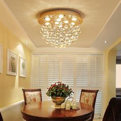 a dining room table with chairs and a vase filled with flowers sitting on top of it