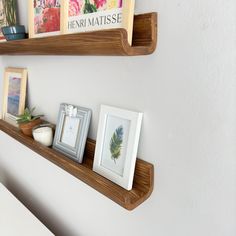 two wooden shelves with pictures and frames on them