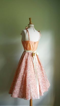 Peaches and cream and sweet as a dream 🍑 This vintage darling dress features straps that tie at the shoulders; a rustling taffeta bodice and lining; an ultra-full skirt with a sweet floral chiffon overlay; and a cream satin sash with a fabric rose and lacy accents at the sweetheart neckline. Peach perfection! Pictured on a US size 2/4 dress form with a crinoline to demonstrate fullness (not included); back nylon zip. This dress arrives professionally cleaned and ready to wear. Era: 1970s Label: 1970s Formal Dress, Peach Satin Dress, 1950s Couture, Couture Clothes, Peach Clothes, 1970 Dress, Peach And Cream, Sweetheart Neckline Dress, Dress Business